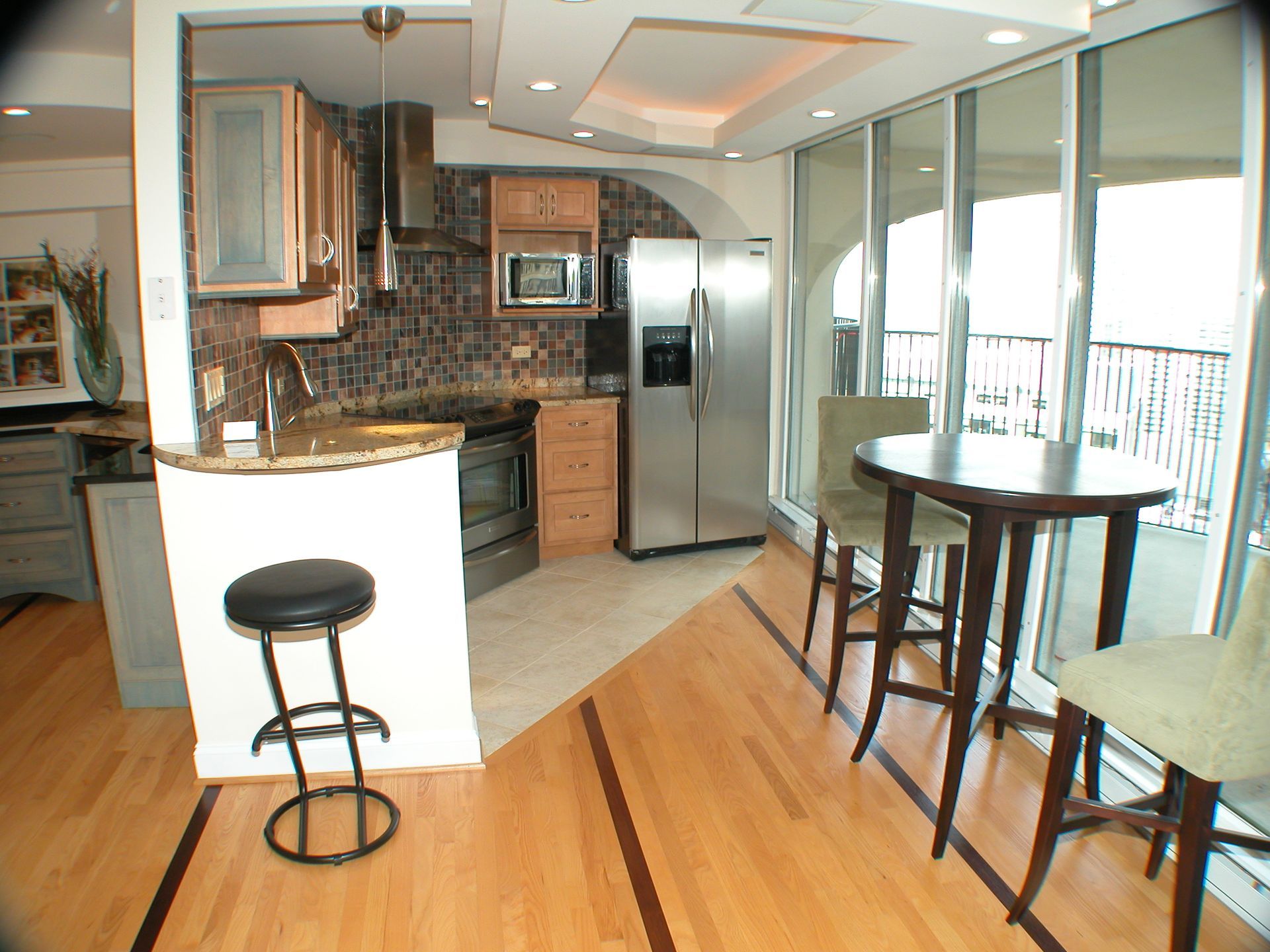 A kitchen with a stainless steel refrigerator and a table