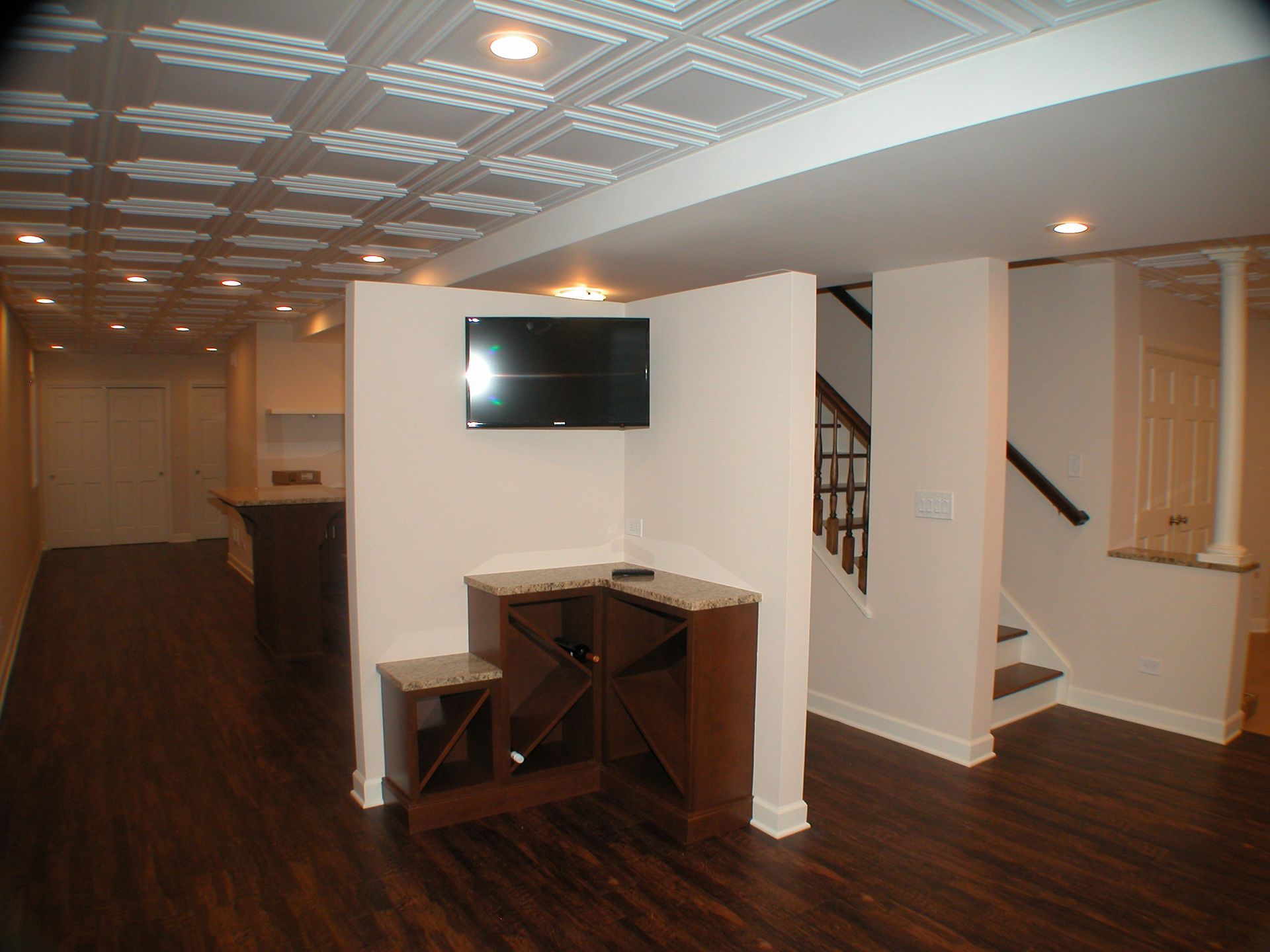 A corner of a room with a tv on the wall