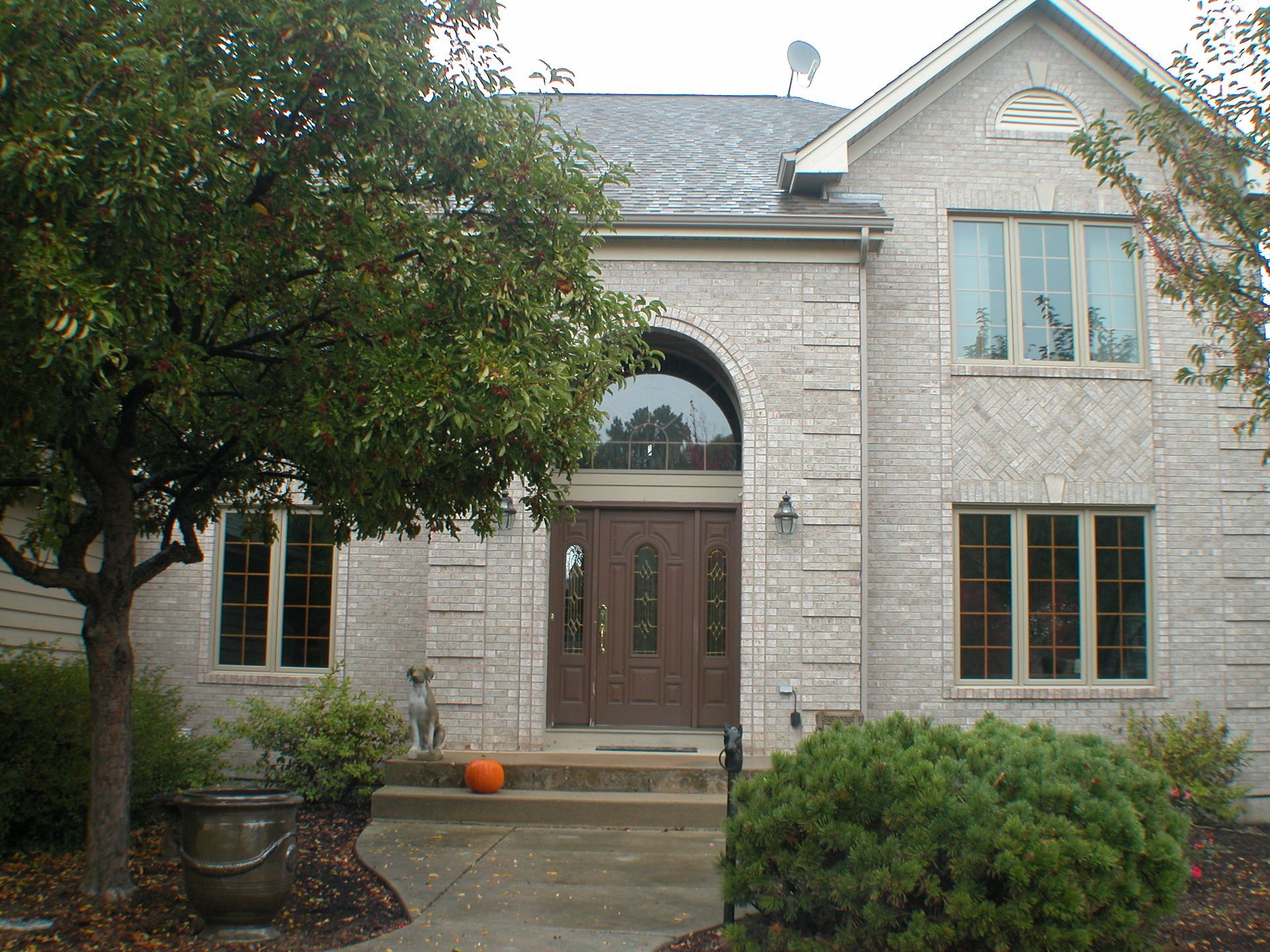 A large brick house with a tree in front of it