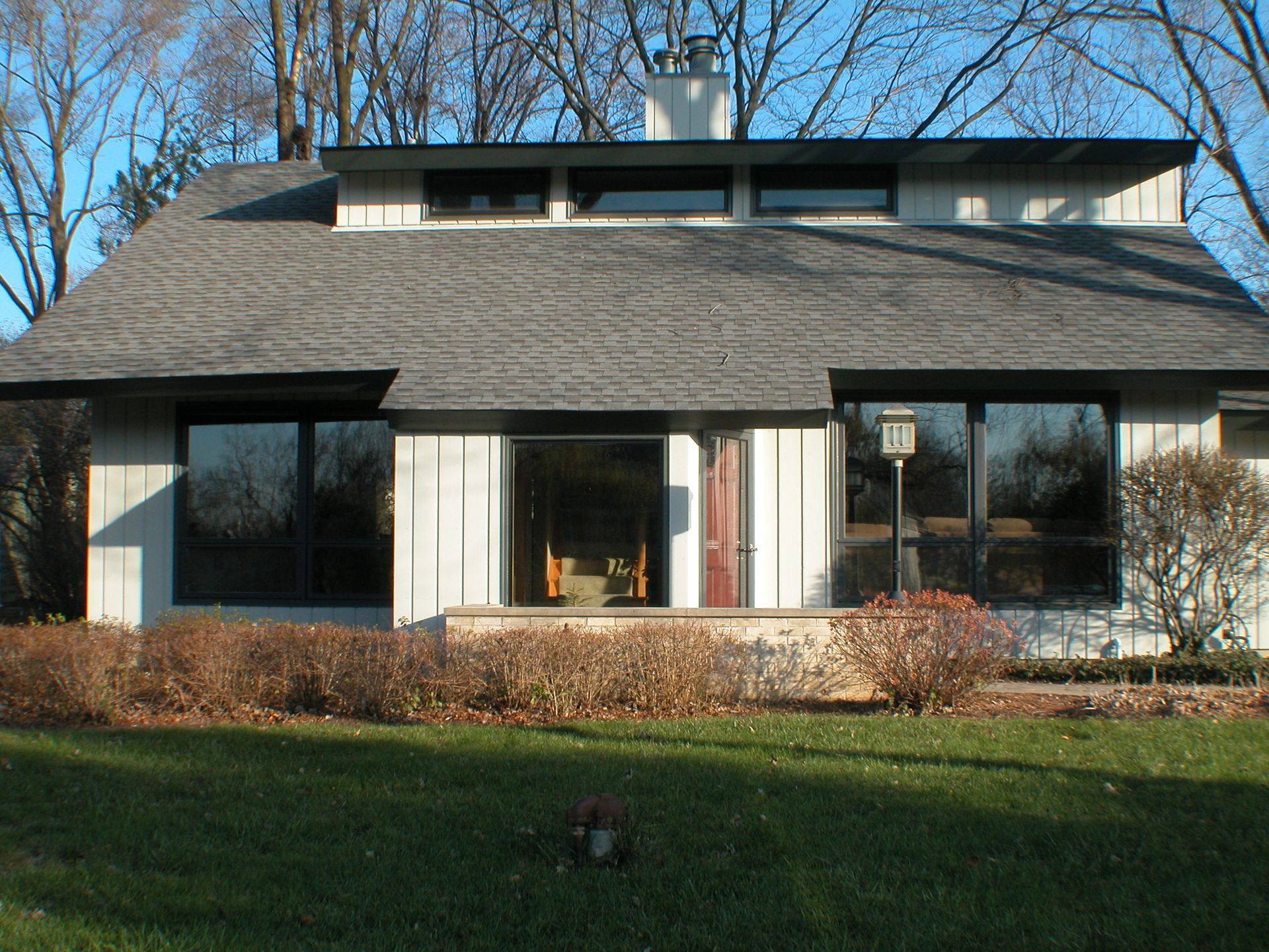 A white house with a gray roof and large windows