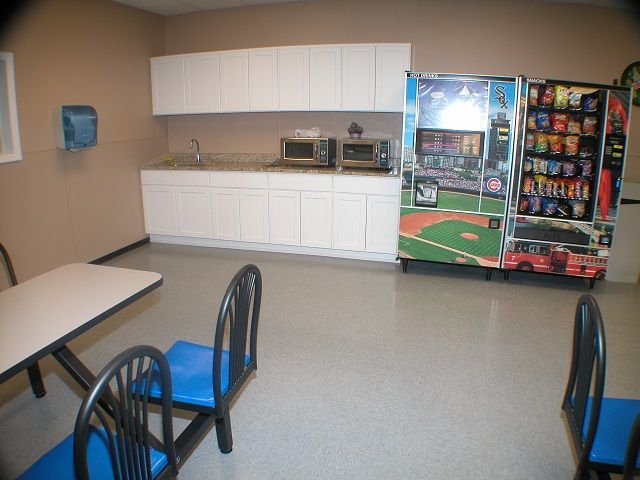 A kitchen with a vending machine that has a baseball field on it