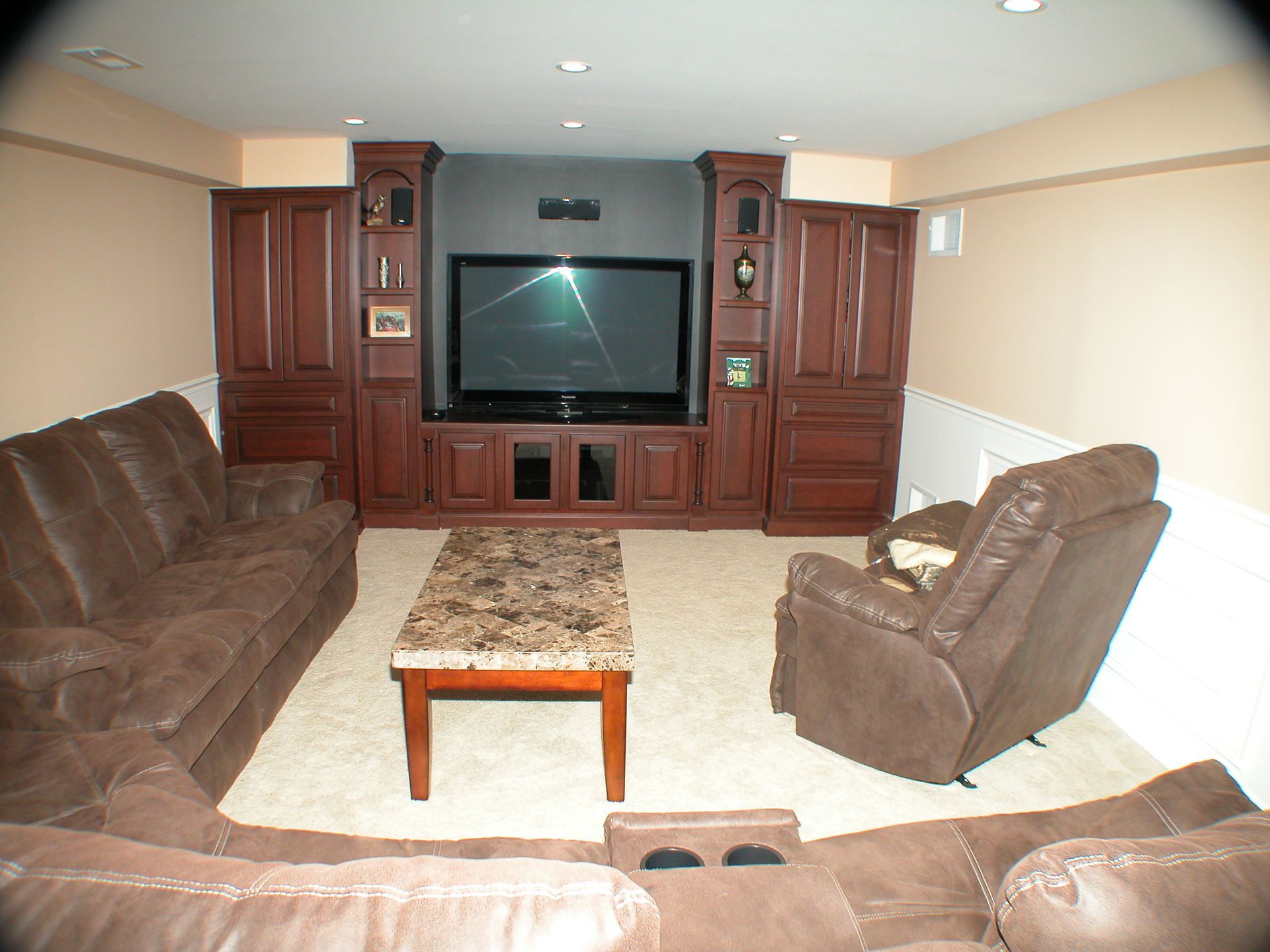 A living room with brown furniture and a flat screen tv