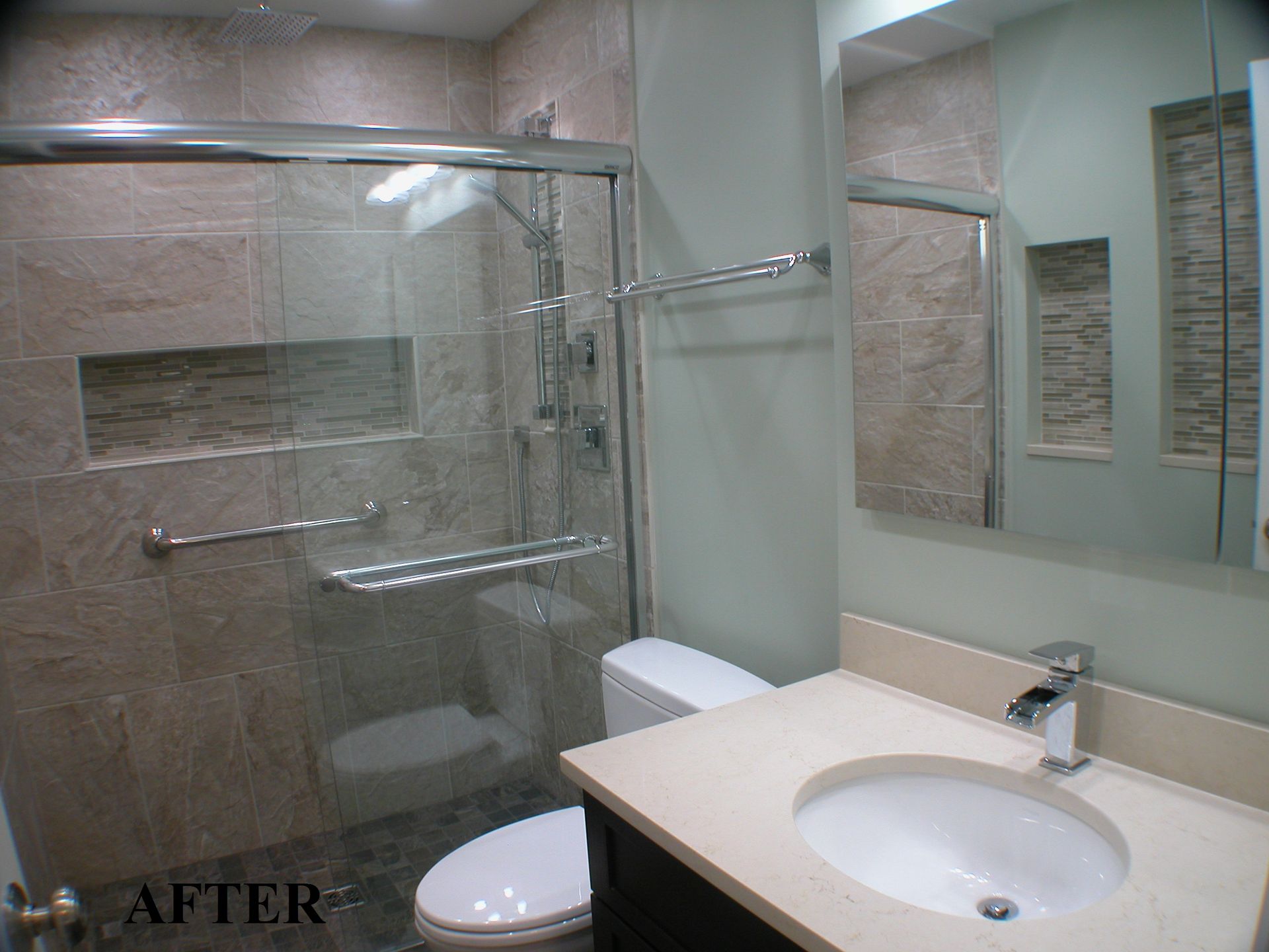 A bathroom with a toilet , sink and shower.