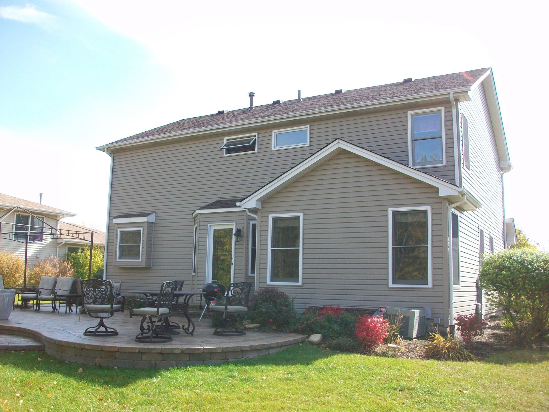 The back of a house with a deck and chairs