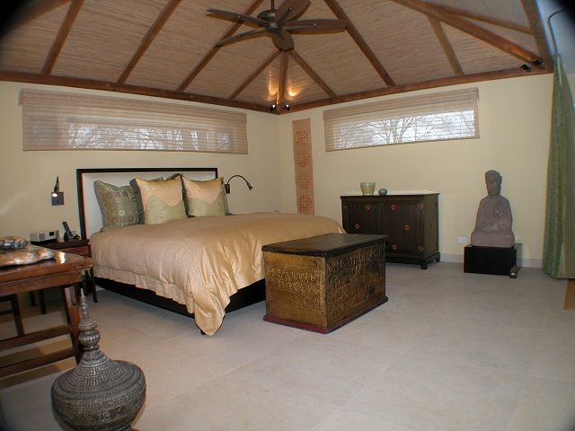 A bedroom with a large bed and a ceiling fan