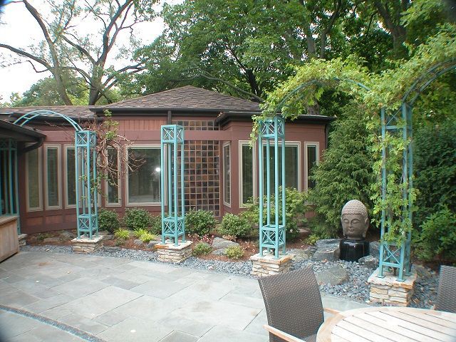 A patio with a table and chairs in front of a house
