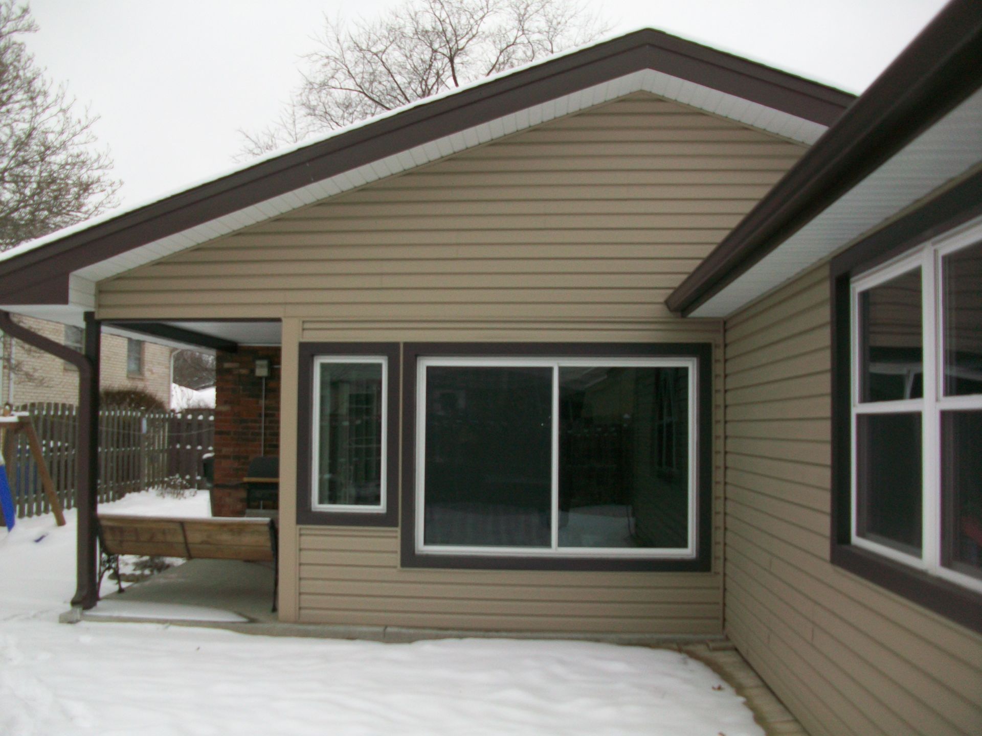 A house with a lot of windows and snow on the ground