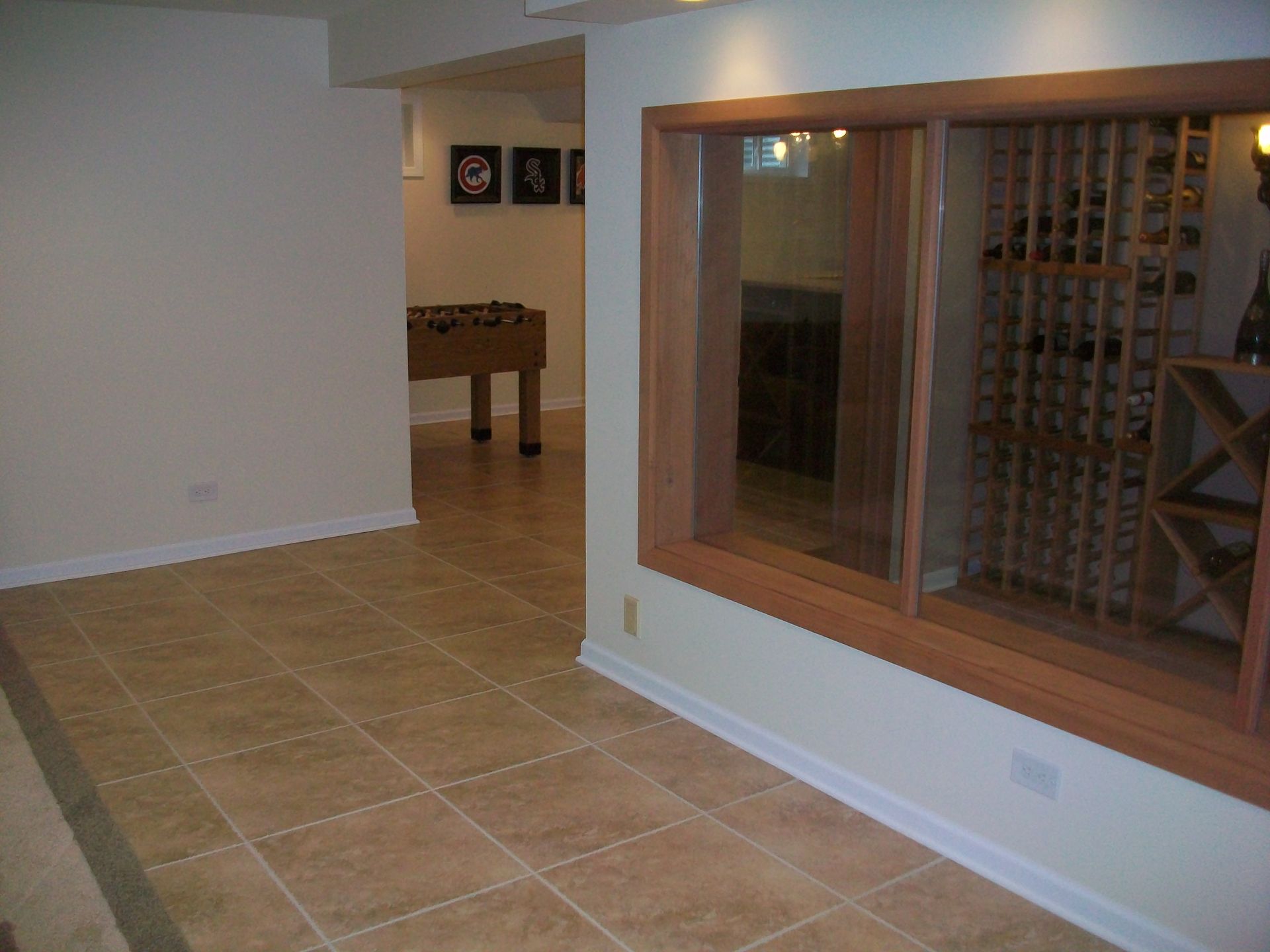 A game room with a foosball table and a wine cellar
