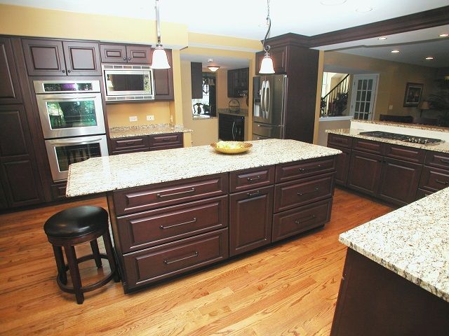 A kitchen with brown cabinets and granite counter tops