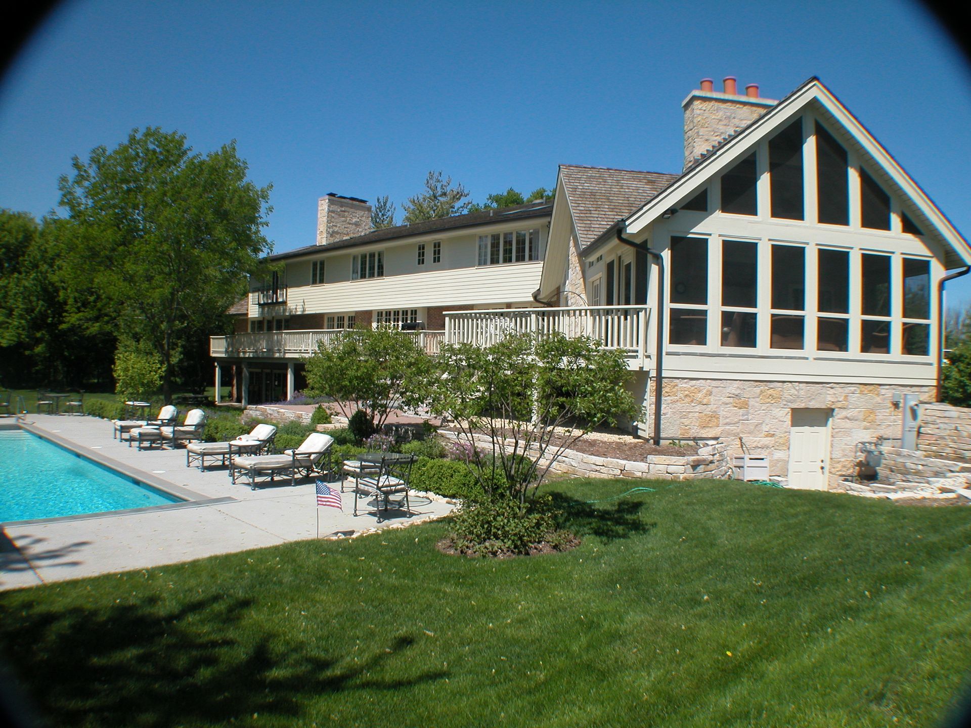 A large house with a swimming pool in front of it