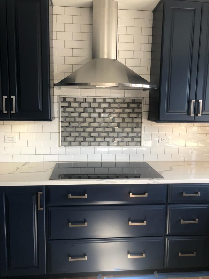 A kitchen with blue cabinets and a stove top oven