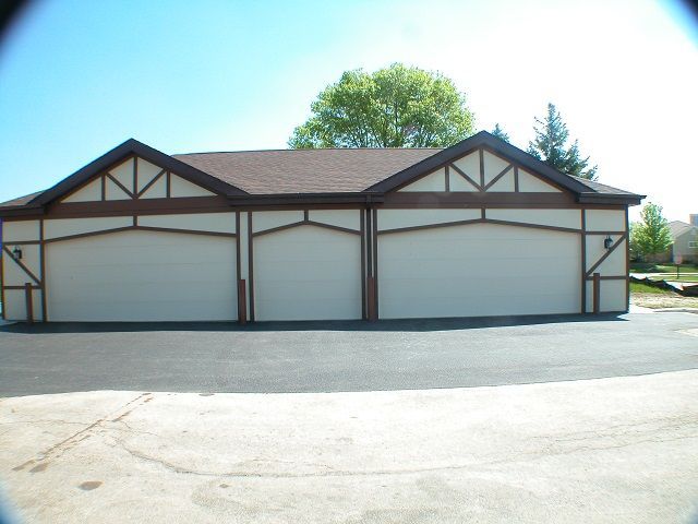A garage with three doors and a brown roof