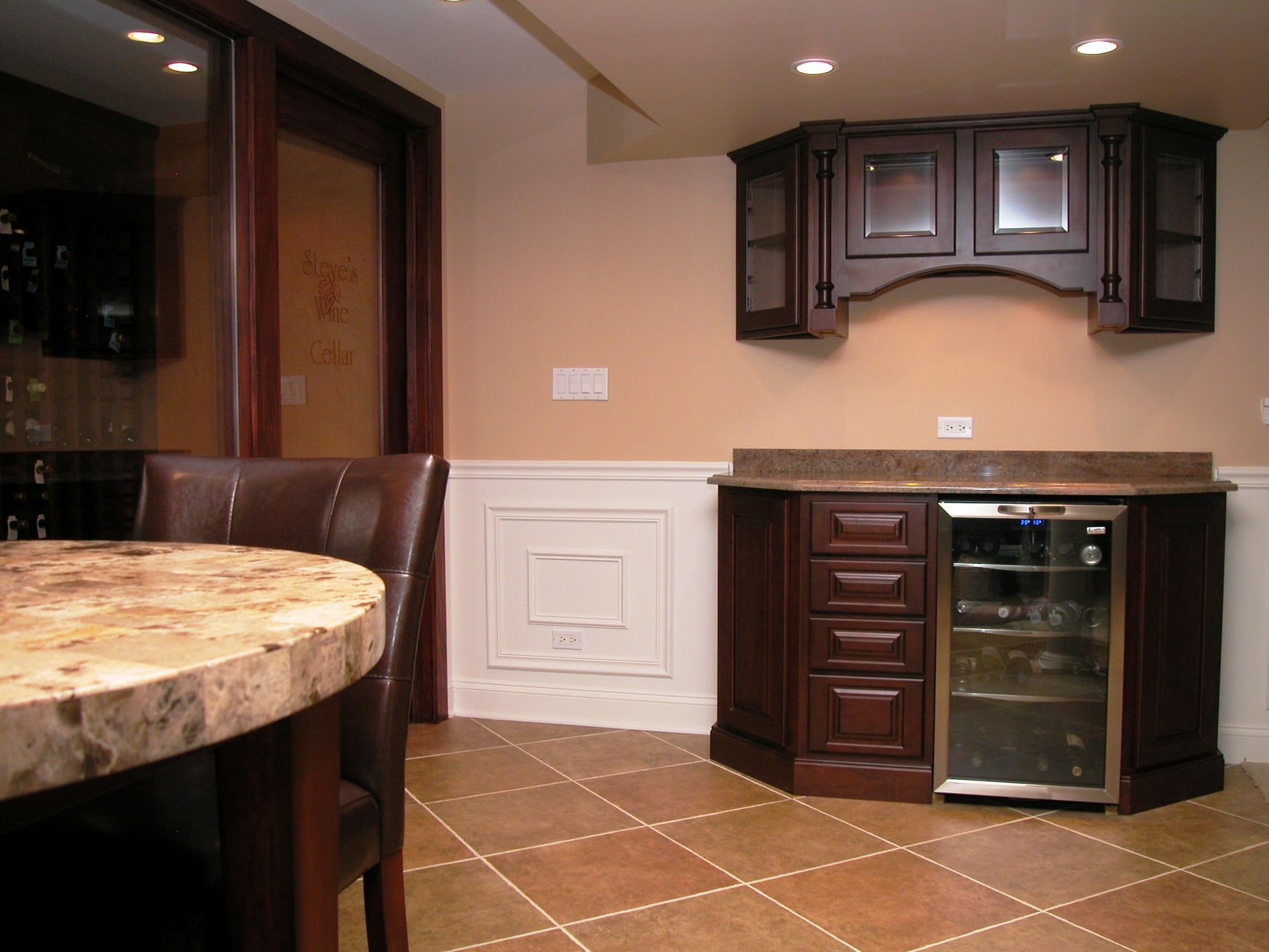 A kitchen with a table and chairs and a refrigerator
