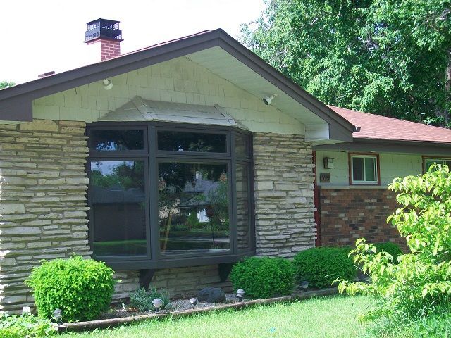 A house with a large window and a chimney on the roof