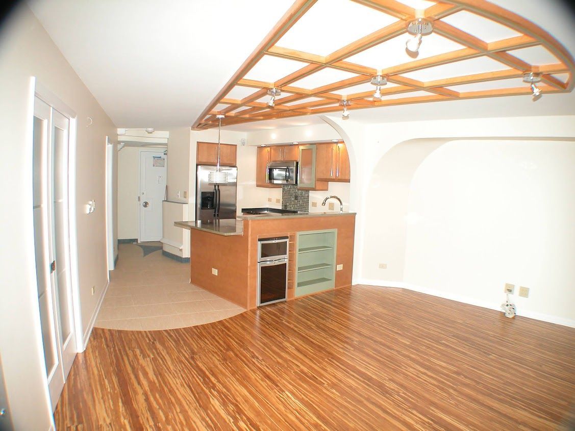 A kitchen with a wooden ceiling and hardwood floors