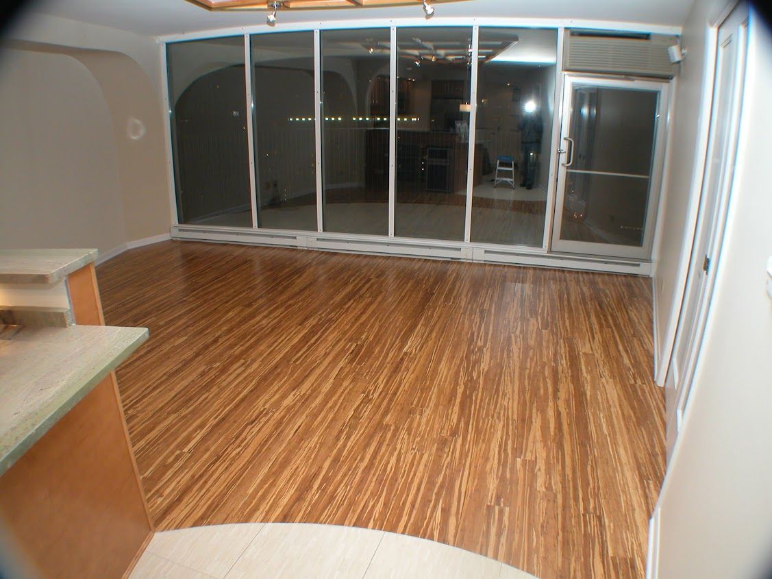 An empty room with hardwood floors and sliding glass doors