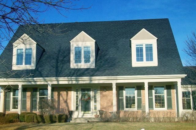 A large house with a black roof and white trim