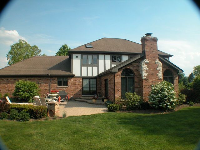 A large brick house with a chimney in the backyard