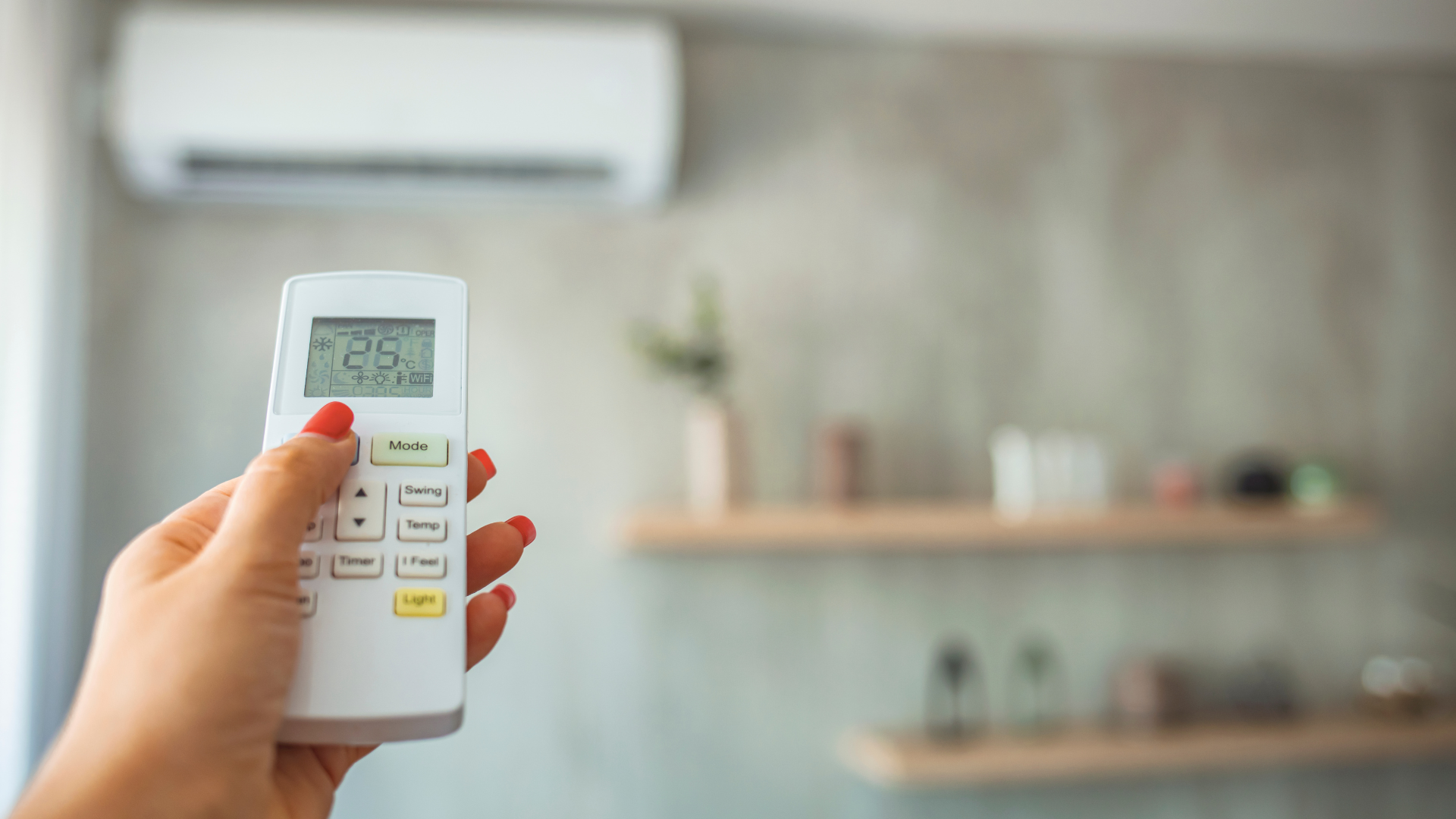 Persona regola il climatizzatore a 26°C per ridurre i consumi durante l’estate