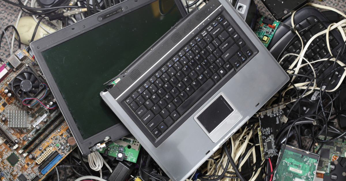 Dispositivi elettronici dismessi tra cavi, computer e schede madri.