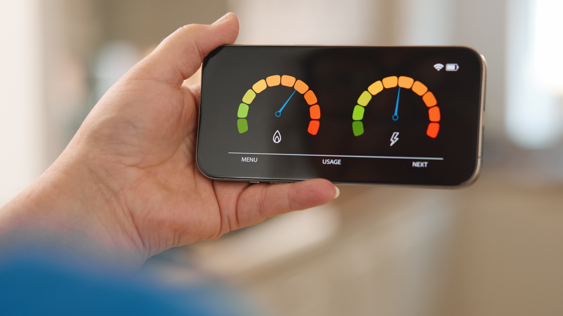 Smartphone con grafici colorati del consumo energetico tenuto in mano: controllo dei consumi.