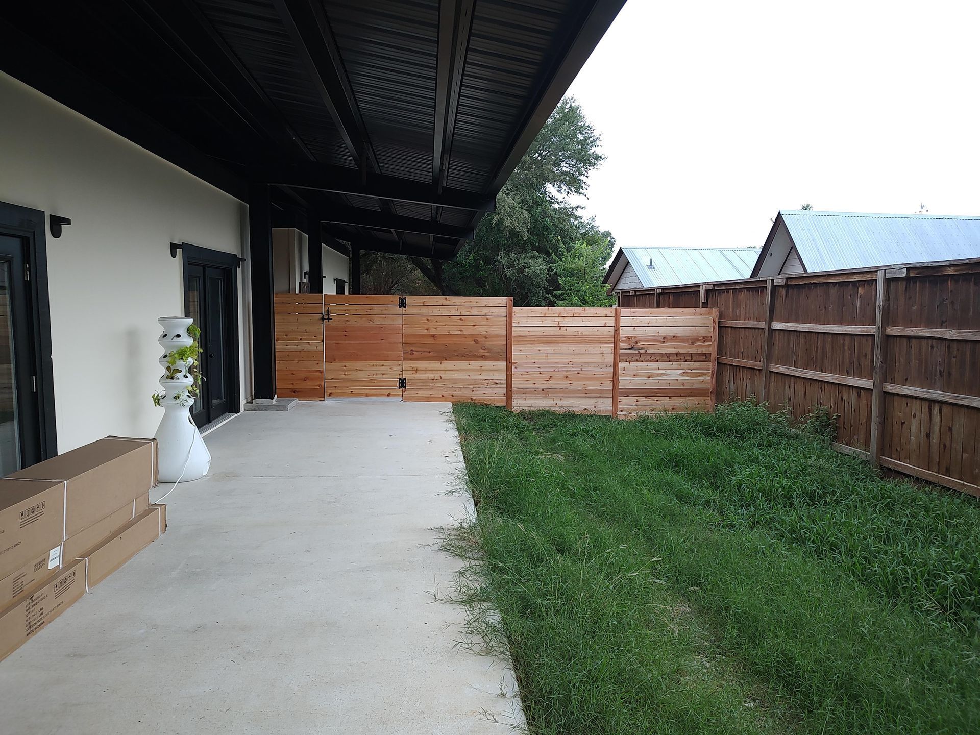 There is a wooden fence in the backyard of a house.