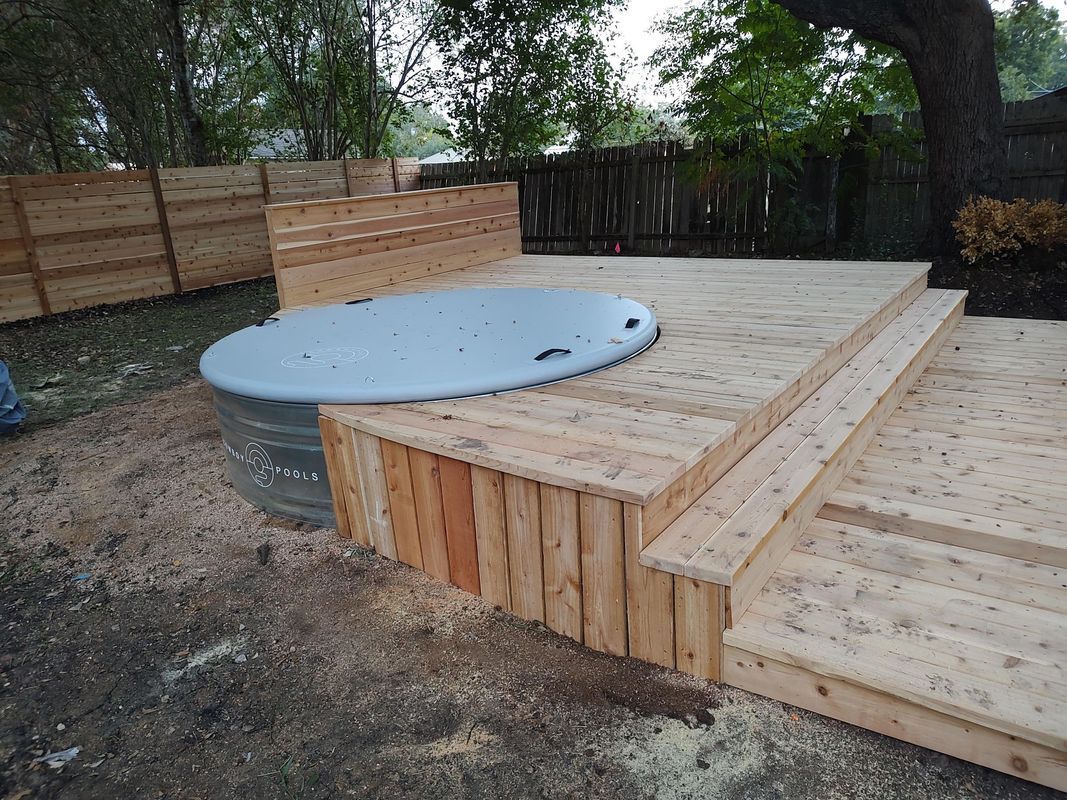 A hot tub is sitting on top of a wooden deck.