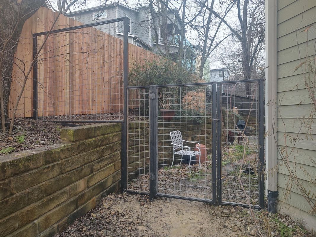 There is a gate in the backyard of a house.