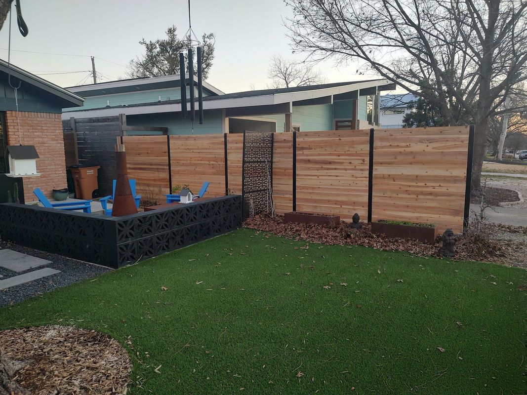 There is a wooden fence in the backyard of a house.