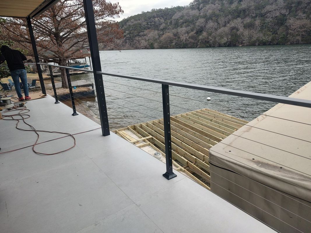 A man is standing on a deck overlooking a lake.