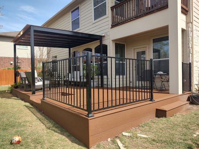 A Wooden Deck With a Metal Railing and a Pergola in the Backyard of a House