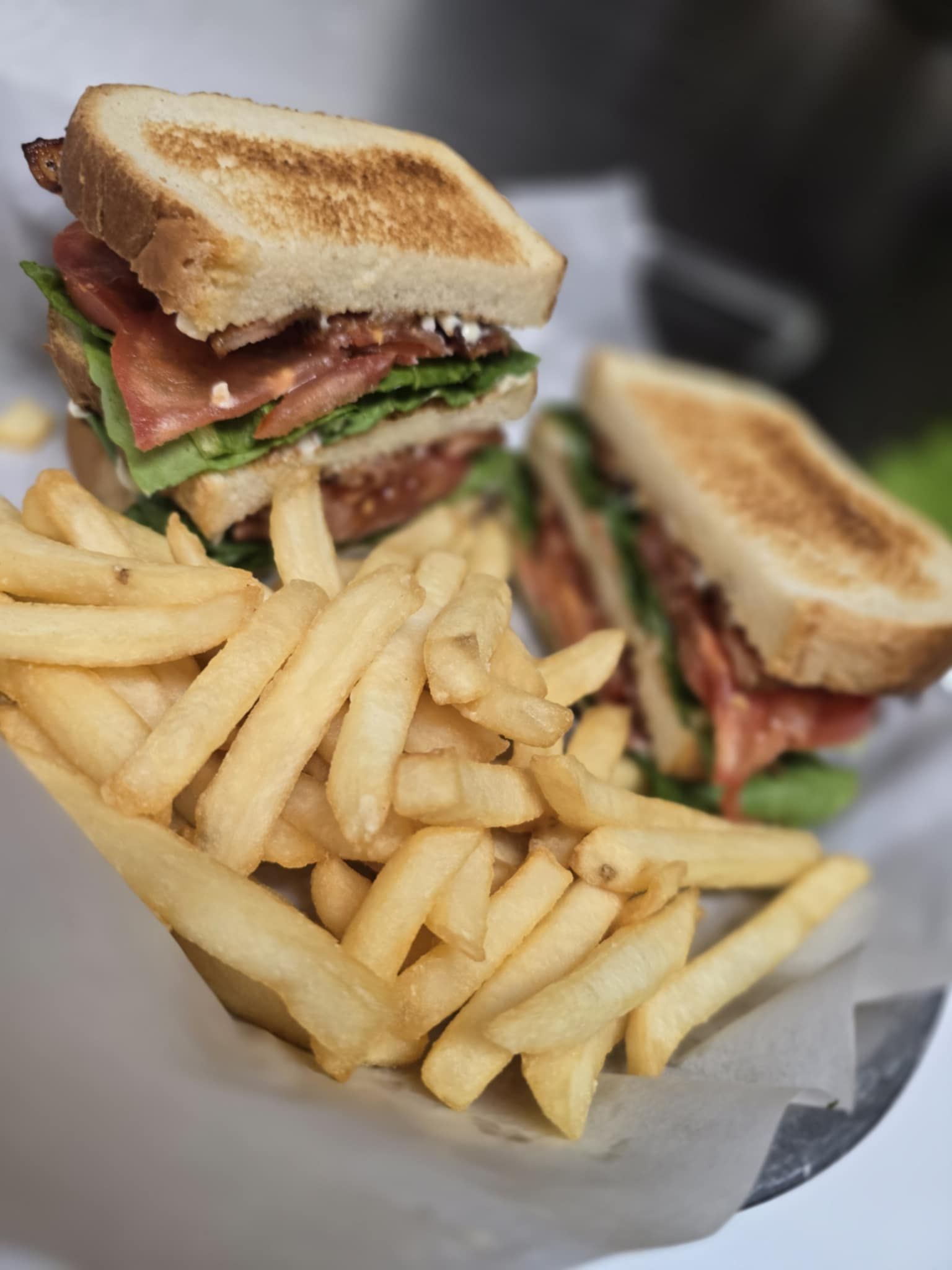 A club sandwich and french fries on a plate