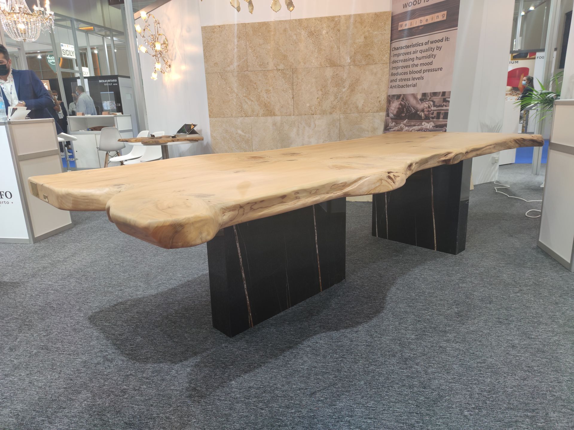 Tavolo da pranzo in legno con supporti neri, in uno showroom.