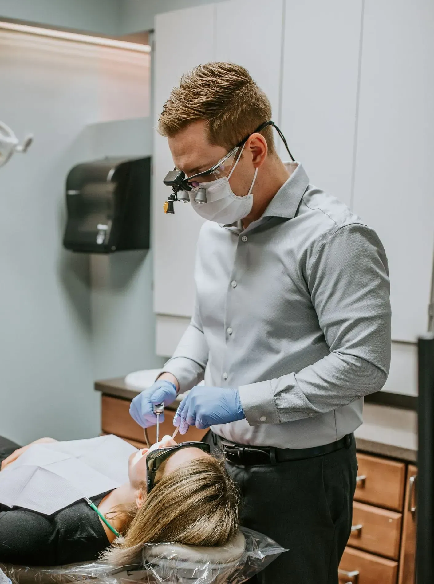 A dentist is taking an x-ray of a patient 's teeth in a dental office.