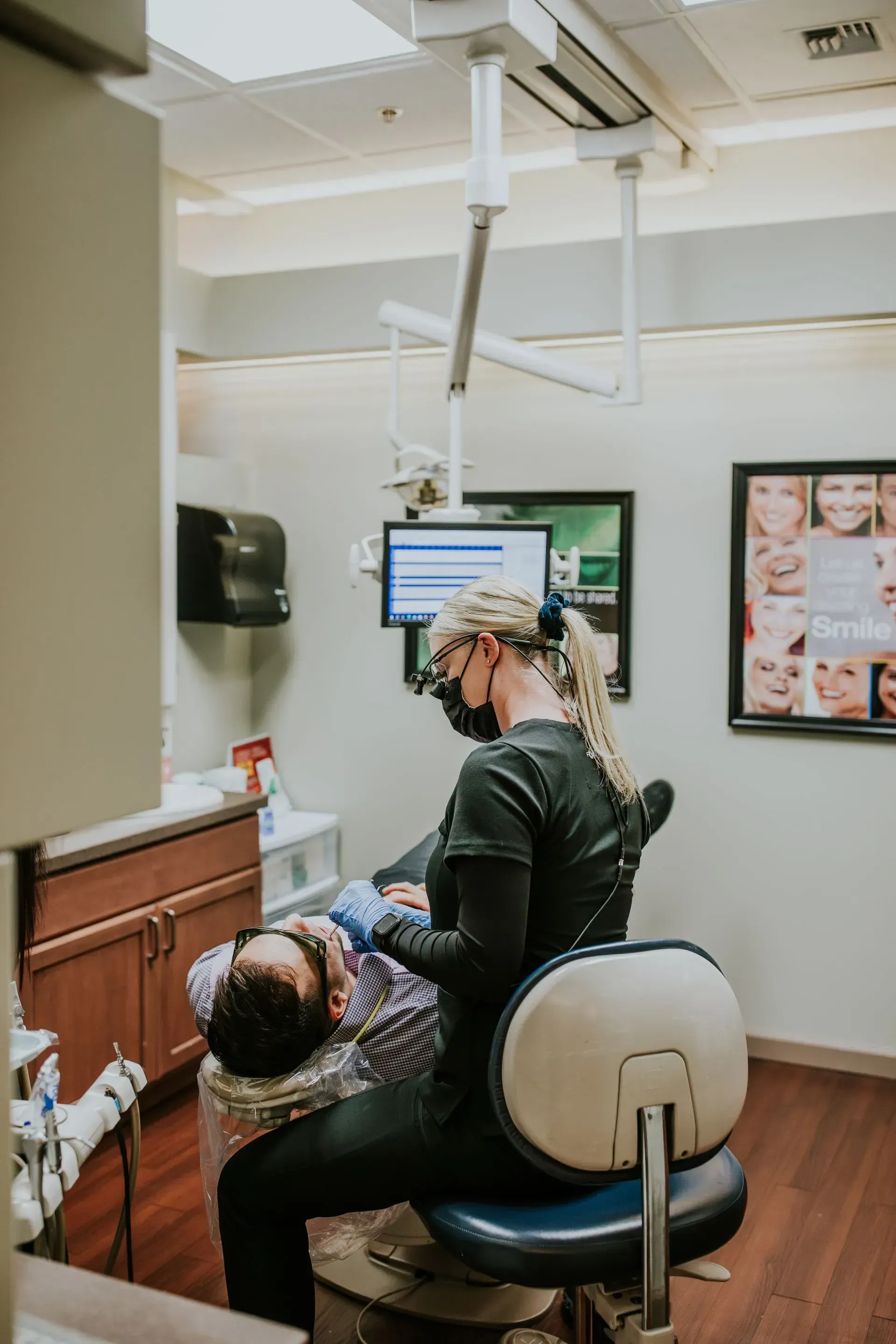 A woman is getting her teeth examined by a dentist.