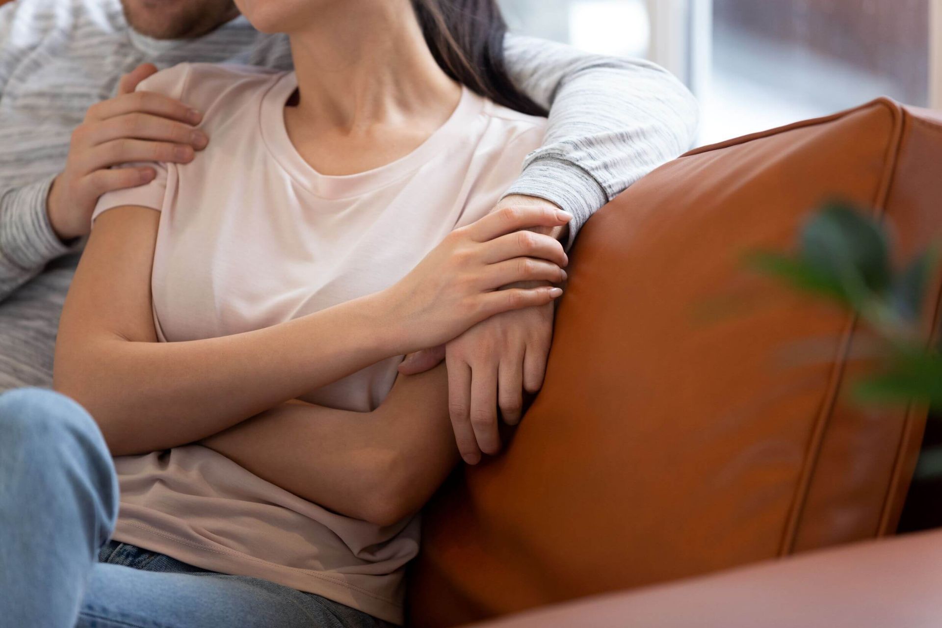 A man is hugging a woman on a couch.