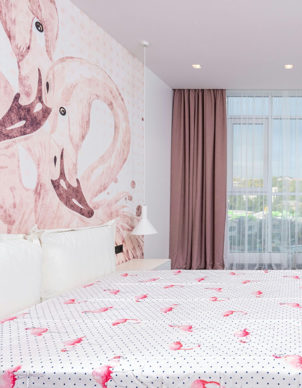 A bedroom with a mirrored dresser and a chandelier hanging from the ceiling.