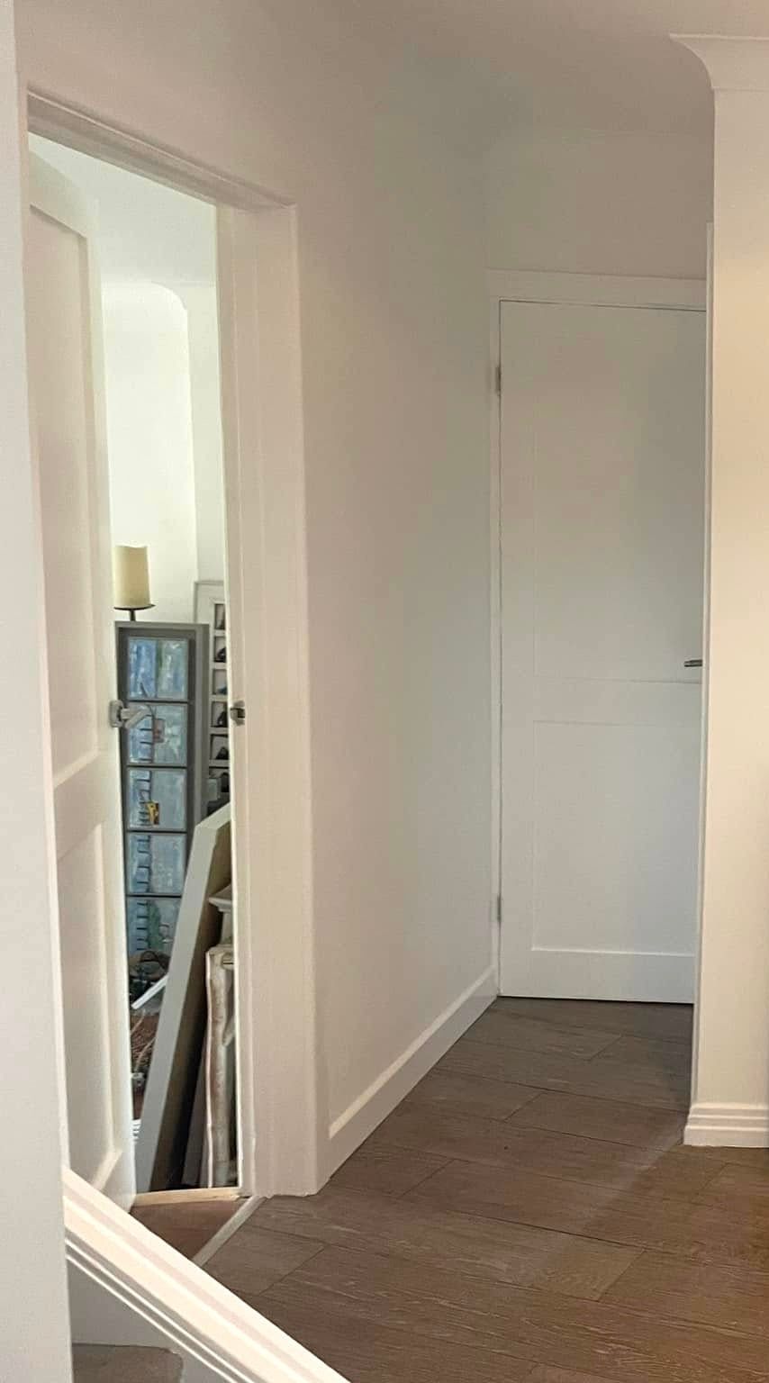 A hallway with stairs leading up to the second floor of a house.