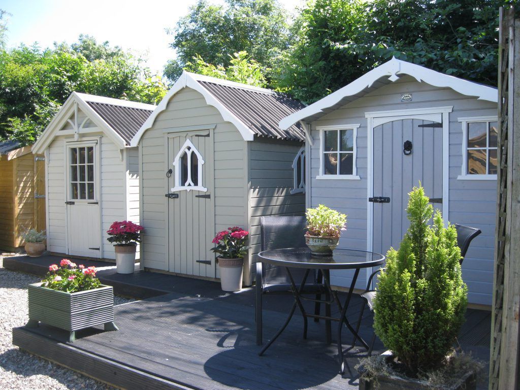 3 lovely garden sheds in a Swansea Welsh garden. Painted in white, green and blue by Daffodil Decor.