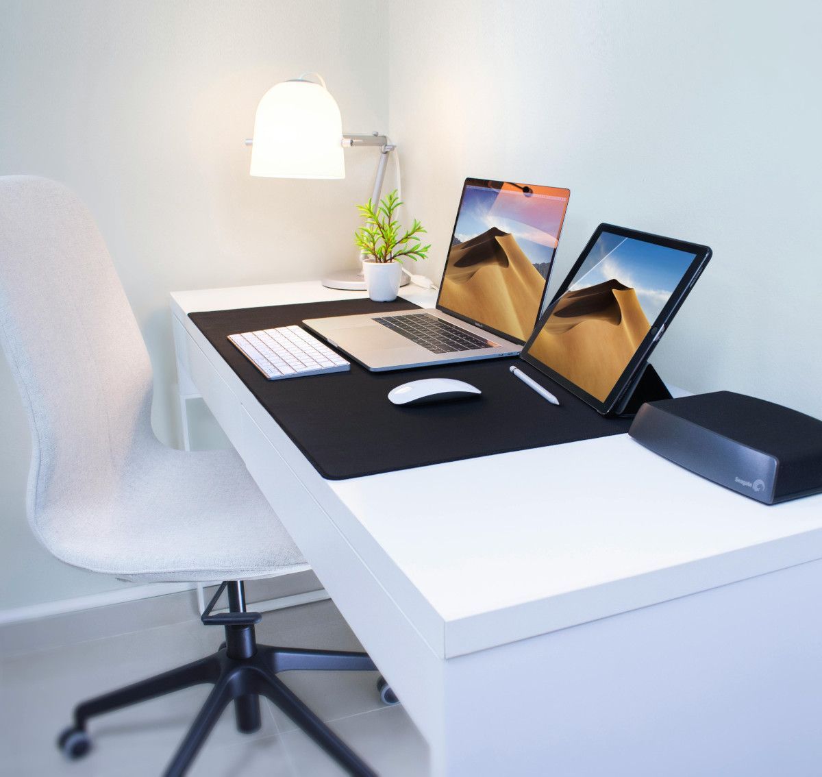 A desk with a laptop and a tablet on it