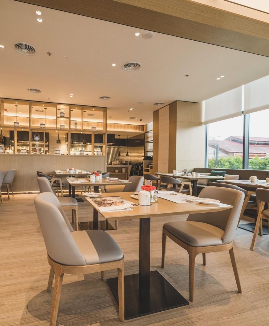 A restaurant with tables and chairs and a large window.