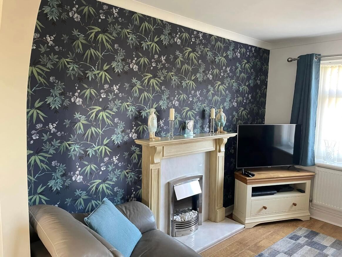 Swansea living room with dark floral wallpaper feature wall by Daffodil Decor.