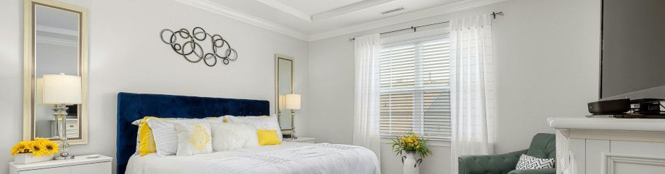 Four-poster bed, sliding door, window shade, quilt, and wardrobe.