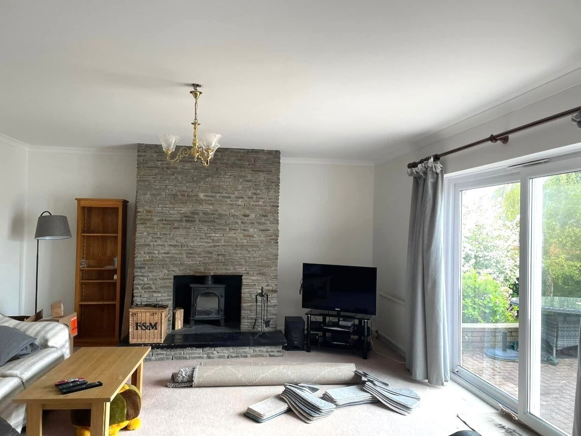 A Swansea living room with a fireplace and a flat screen tv. Painted and decorated by Daffodil Decor.