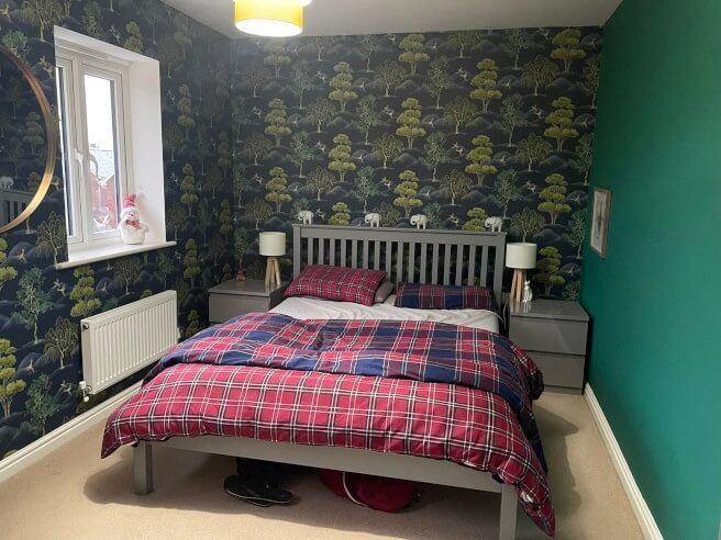 Bedroom with wallpaper installation of green trees and elephants in a Mumbles home in Swansea by Daffodil Decor.