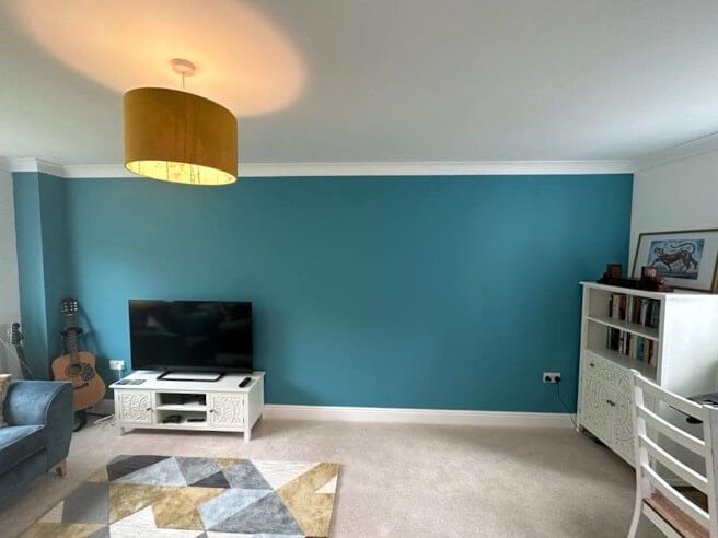 Interior feature wall wallpaper installation in a Mumbles (Swansea) home with green plant and flower design, installed by Daffodil Decor.
