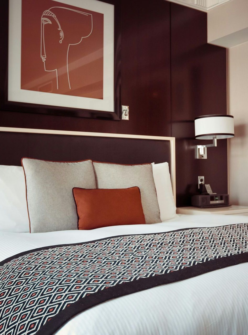 A hotel room with a bed and a picture on the wall