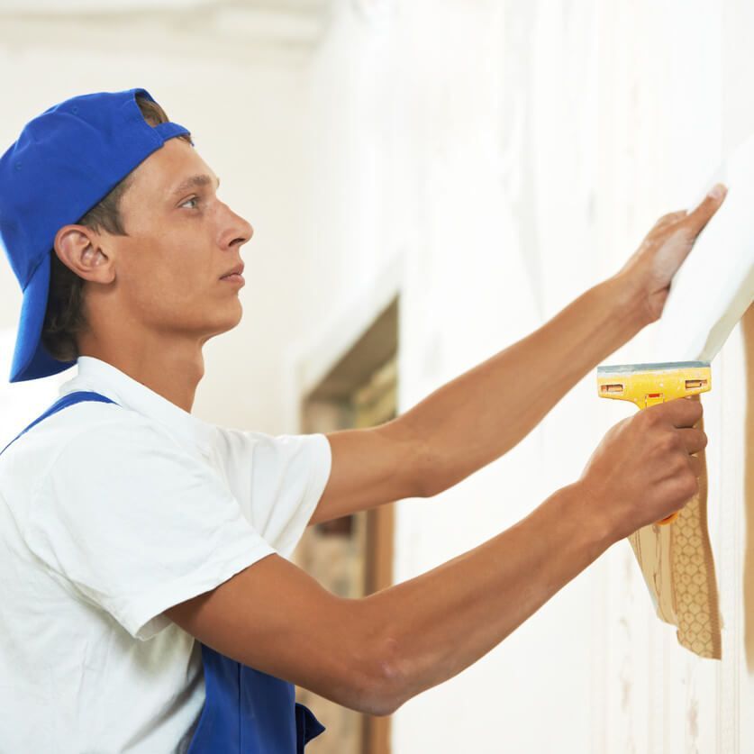 A kitchen with a bar and stools and a clock on the wall.