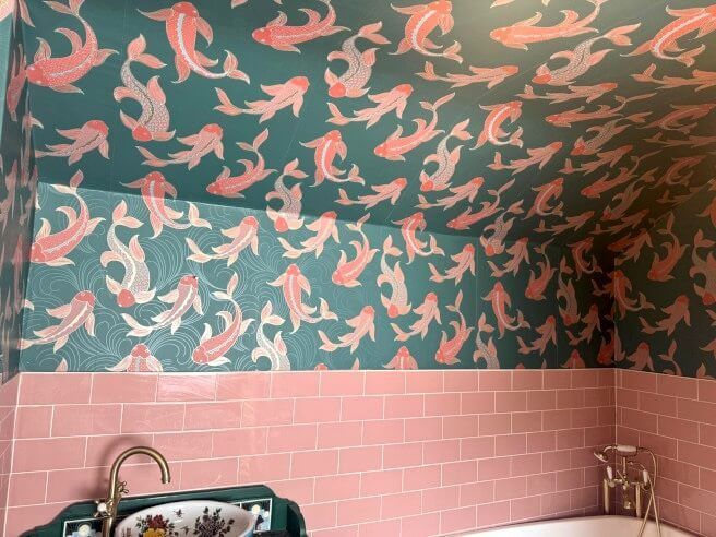 Bathroom with pink brick tile walls, teal walls and ceiling covered in pink fish pattern.
