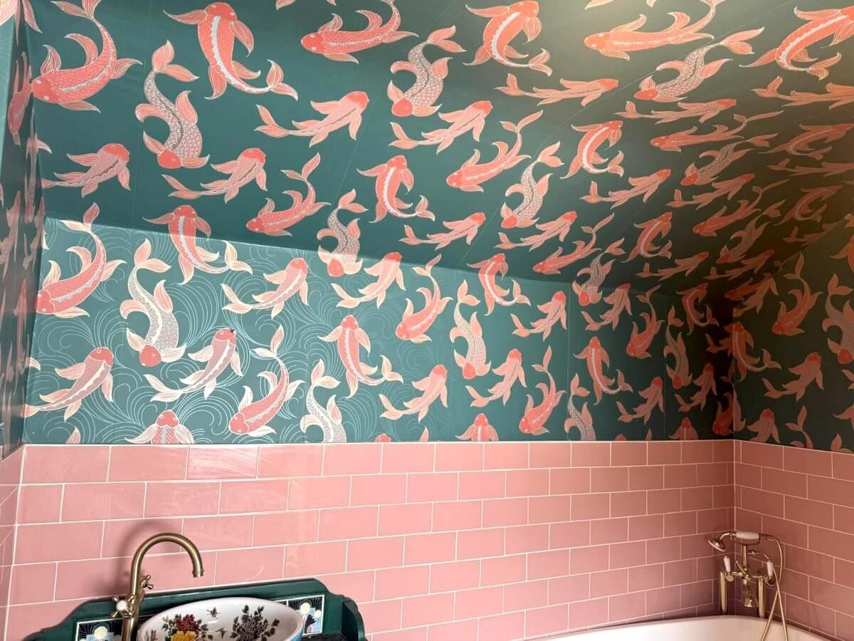 Bathroom with pink tile, teal walls and ceiling with repeating salmon-colored koi fish pattern. Wallpapered by Daffodil Decor in Swansea.